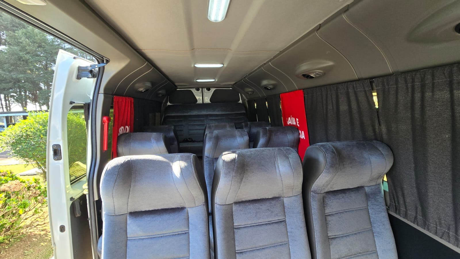 Interior da van da FlexVan com poltronas reclináveis para viagem de grupo em Curitiba
